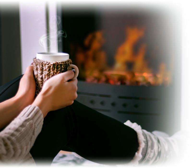 woman-with-hot-drink-front-fireplace